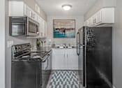 Thumbnail 5 of 30 - a kitchen with white cabinets and black appliances