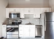 Thumbnail 9 of 24 - a kitchen with white cabinets and stainless steel appliances