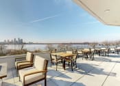 Thumbnail 32 of 53 - a patio with tables and chairs overlooking a river and a city at Current812, Clarksville