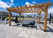Thumbnail 43 of 48 - Outdoor patio lounge area with wooden pergola at Allure Apartments, Indiana