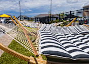 Thumbnail 42 of 48 - Outdoor hammocks with striped cushions and yellow umbrella at Allure Apartments, Whiteland