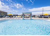 Thumbnail 17 of 48 - Swimming pool with modern pergola and yellow umbrellas at Allure Apartments, Indiana