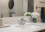 Thumbnail 8 of 60 - A white sink with a silver faucet and a vase of white flowers on the counter at Current812, Clarksville, Indiana