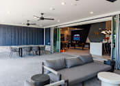 Thumbnail 14 of 29 - A living room with a grey sofa and a dining table at The Warren Apartments, Jeffersonville, IN