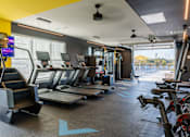 Thumbnail 20 of 29 - A gym with treadmills, exercise bikes, and other equipment at The Warren Apartments, Jeffersonville, IN