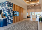 Thumbnail 21 of 29 - A reception area with a blue and white wall and a wooden panel at The Warren Apartments, Jeffersonville, IN