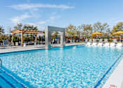 Thumbnail 13 of 29 - A large swimming pool with a blue tinted water and a white line around it at The Warren Apartments, Jeffersonville, IN