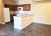 Thumbnail 2 of 10 - A kitchen with a white refrigerator and brown cabinets.