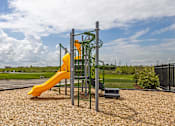Thumbnail 26 of 29 - A playground with a yellow slide and a green climbing structure at The Warren Apartments, Indiana