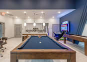 Thumbnail 18 of 29 - A pool table is in the middle of a room with a TV on the wall at The Warren Apartments, Jeffersonville, IN