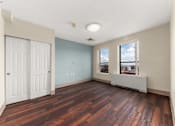 Thumbnail 33 of 68 - A room with a wooden floor and a window with a view of the city at 206 Flats Apartments, Washington