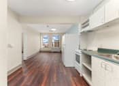 Thumbnail 6 of 68 - A kitchen with white cabinets and a wooden floor at 206 Flats Apartments, Washington