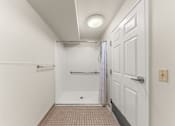 Thumbnail 58 of 68 - A white bathroom with a tiled floor and a shower at 206 Flats Apartments, Spokane 99201