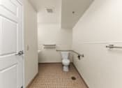 Thumbnail 57 of 68 - A white door is open to a small bathroom with a toilet and a sink at 206 Flats Apartments, Spokane, WA