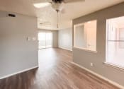 Thumbnail 20 of 24 - an empty living room and dining room with wood flooring and a window