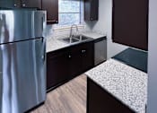 Thumbnail 18 of 24 - an empty kitchen with granite counter tops and stainless steel refrigerator