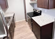 Thumbnail 23 of 24 - a kitchen with granite countertops and stainless steel appliances and wooden cabinets