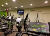 Thumbnail 6 of 23 - a room filled with lots of cardio equipment and a flat screen tv