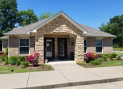 Thumbnail 4 of 14 - a house with a stone facade and a concrete sidewalk in front of it