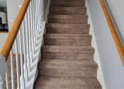 Thumbnail 9 of 23 - a view from the top of the stairs looking down into the living room