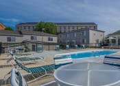 Thumbnail 8 of 23 - a swimming pool with chairs and tables around it