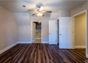 Thumbnail 12 of 18 - a bedroom with hardwood floors and a ceiling fan