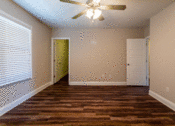 Thumbnail 4 of 18 - a bedroom with hardwood floors and a ceiling fan