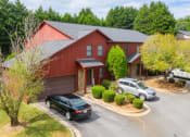 Thumbnail 18 of 23 - a red house with a black car parked in front of it
