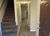 Thumbnail 17 of 23 - a hallway with a stairs and a door