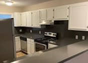Thumbnail 15 of 23 - a kitchen with white cabinets and stainless steel appliances