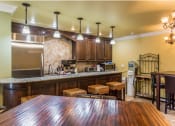 Thumbnail 9 of 14 - a kitchen and dining area with a wooden table and stools