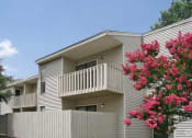 Thumbnail 3 of 19 - a white house with a balcony and pink flowers