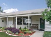 Thumbnail 2 of 19 - a white house with a porch and a flower garden