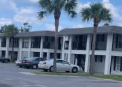 Thumbnail 1 of 9 - a building with two palm trees in front of it
