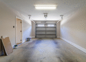 Thumbnail 9 of 18 - an empty garage with a garage door open