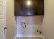 Thumbnail 13 of 18 - a laundry room with dark cabinets and a white door