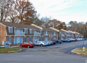 Thumbnail 3 of 13 - a row of houses with cars parked in front of them