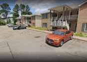 Thumbnail 2 of 13 - a row of apartment buildings with cars parked in front of them
