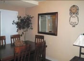 Thumbnail 6 of 11 - a dining room with a table and chairs and a clock on the wall