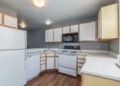Thumbnail 21 of 23 - a kitchen with white appliances and wooden cabinets