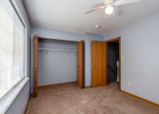 Thumbnail 22 of 23 - a bedroom with a closet and a window and a ceiling fan
