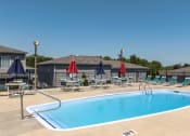 Thumbnail 17 of 23 - a swimming pool with chairs and umbrellas next to a house