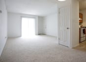Thumbnail 1 of 15 - a bedroom with an open door and a kitchen in the background