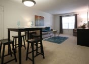 Thumbnail 9 of 15 - a living room with a couch and a table with stools