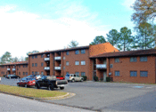 Thumbnail 1 of 13 - a large brick building with cars parked in front of it