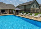 Thumbnail 8 of 14 - a swimming pool with chaise lounges and umbrellas in front of a house