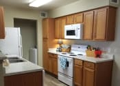 Thumbnail 2 of 14 - a kitchen with white appliances and wooden cabinets