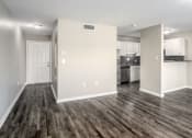 Thumbnail 2 of 23 - an empty living room with a kitchen in the background