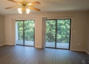 Thumbnail 1 of 23 - an empty living room with a ceiling fan and sliding glass doors