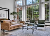 Thumbnail 21 of 25 - a living room with a couch and chairs and large windows
